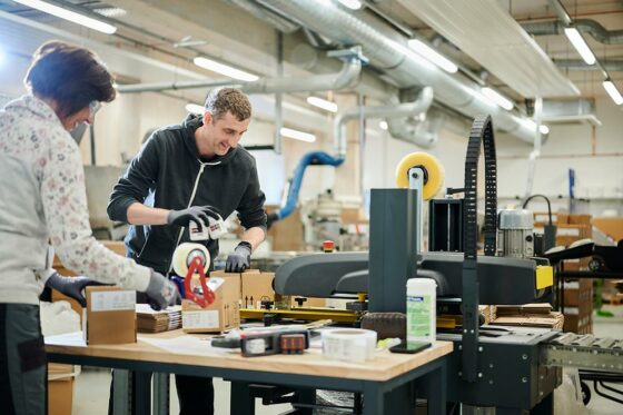 Two employees label and package cleaning products on behalf of a customer.